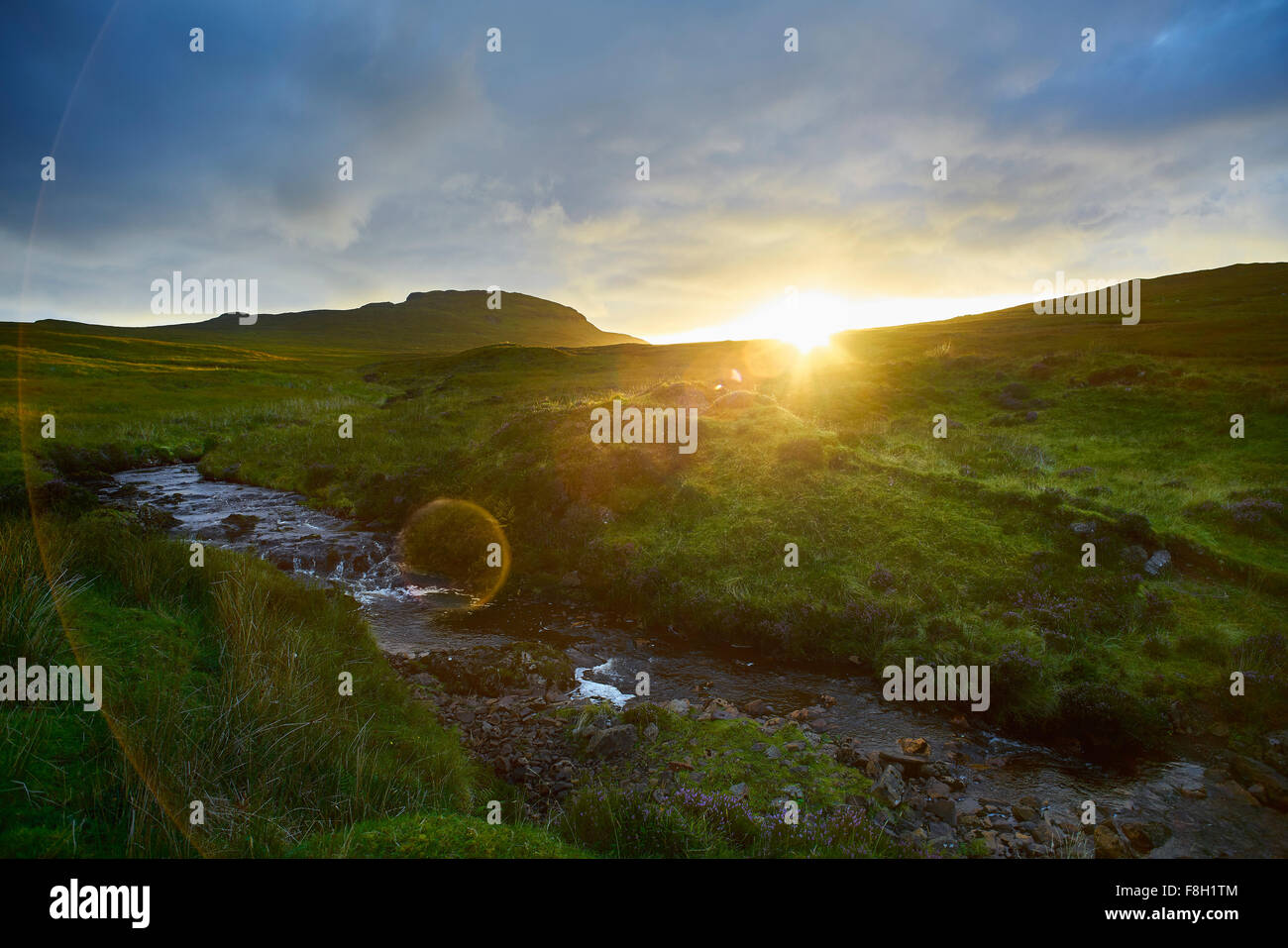 Sonnenaufgang über dem ländlichen Hügeln und stream Stockfoto