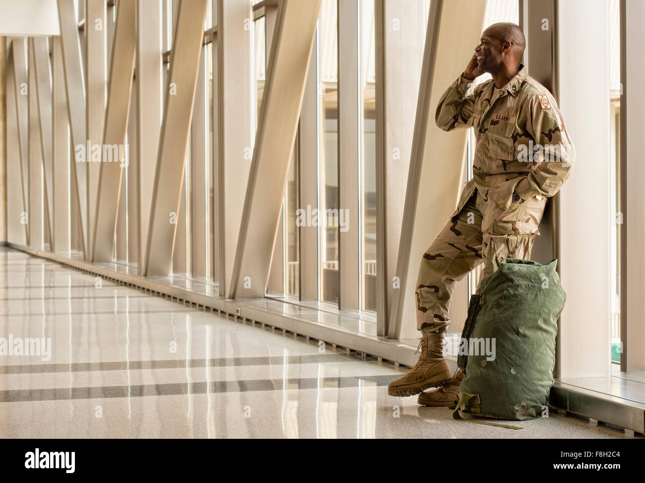 Afrikanische amerikanische Soldaten reden über Handy im Flughafen Stockfoto