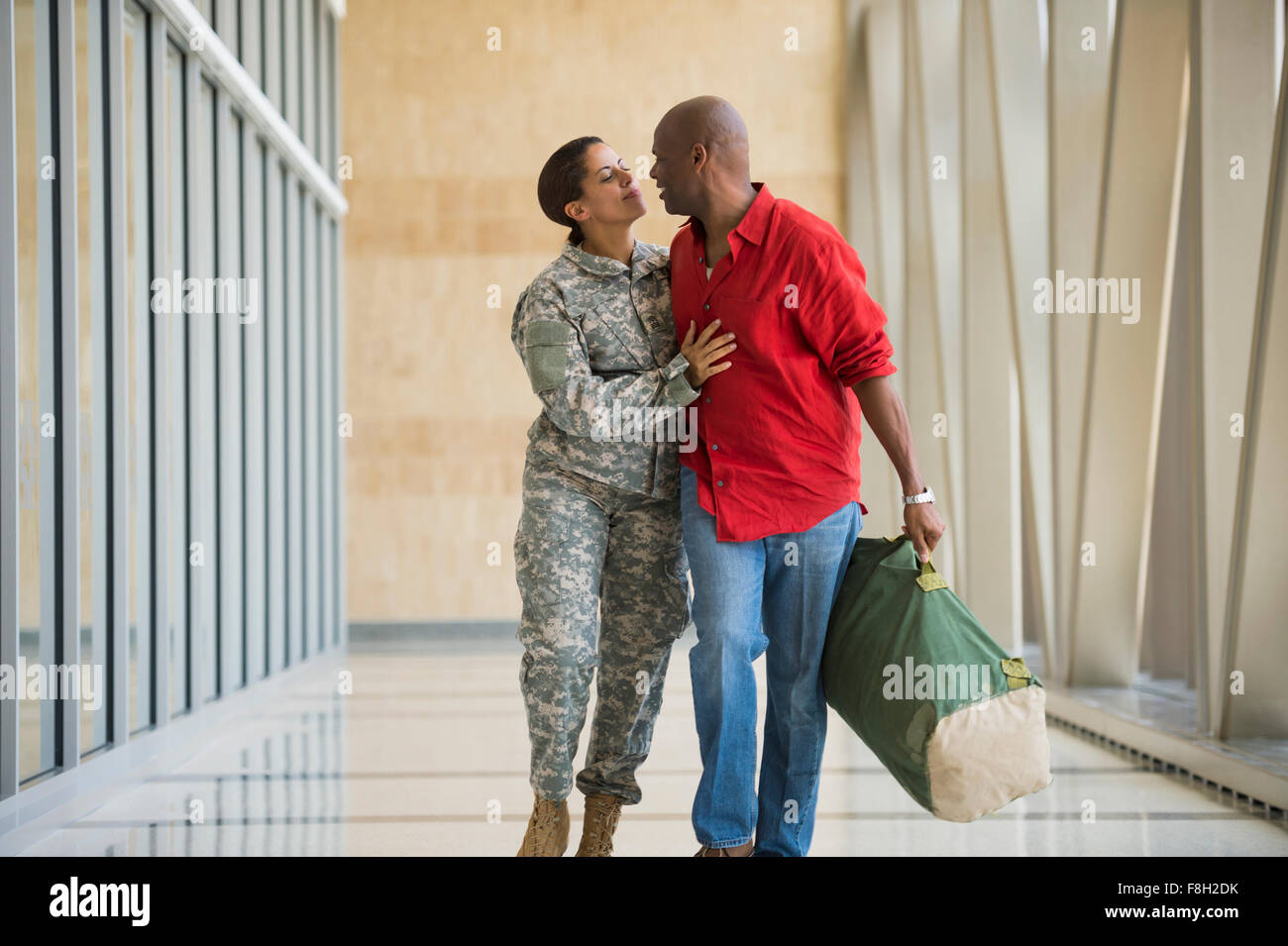 Afrikanische amerikanische Soldaten im Gespräch mit Ehemann in Flughafen Stockfoto