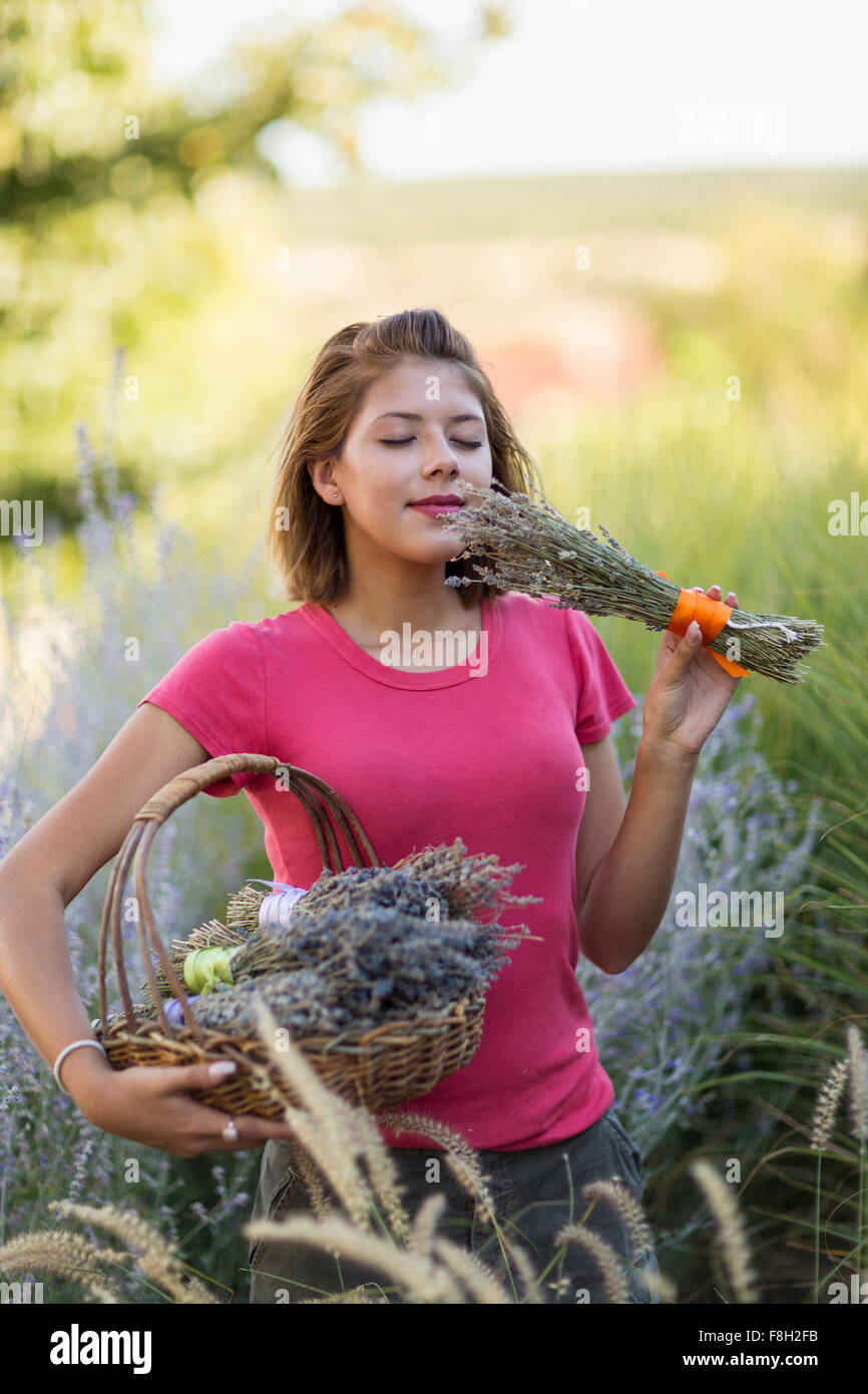 Gemischte Rassen Frau duftende Blumen im Garten Stockfoto