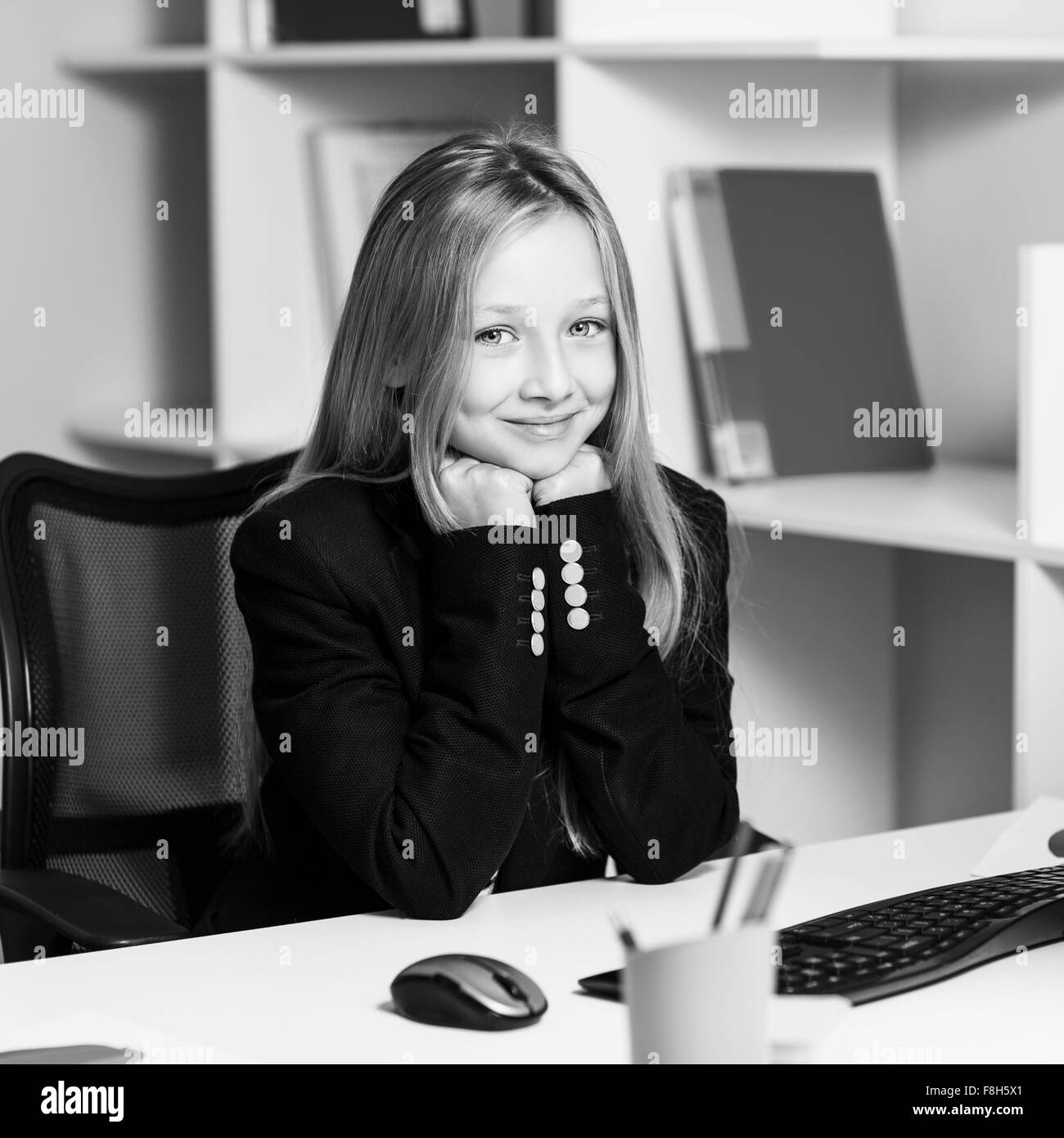 Kleines Mädchen wie Business-Frau am Tisch Stockfoto