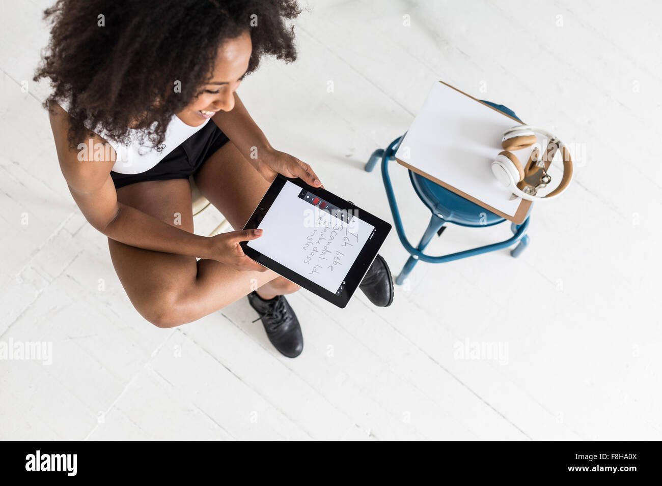 Eine junge Afro-amerikanische Frau mit einem Tablet oder iPad in einem Studio Typ festlegen Stockfoto