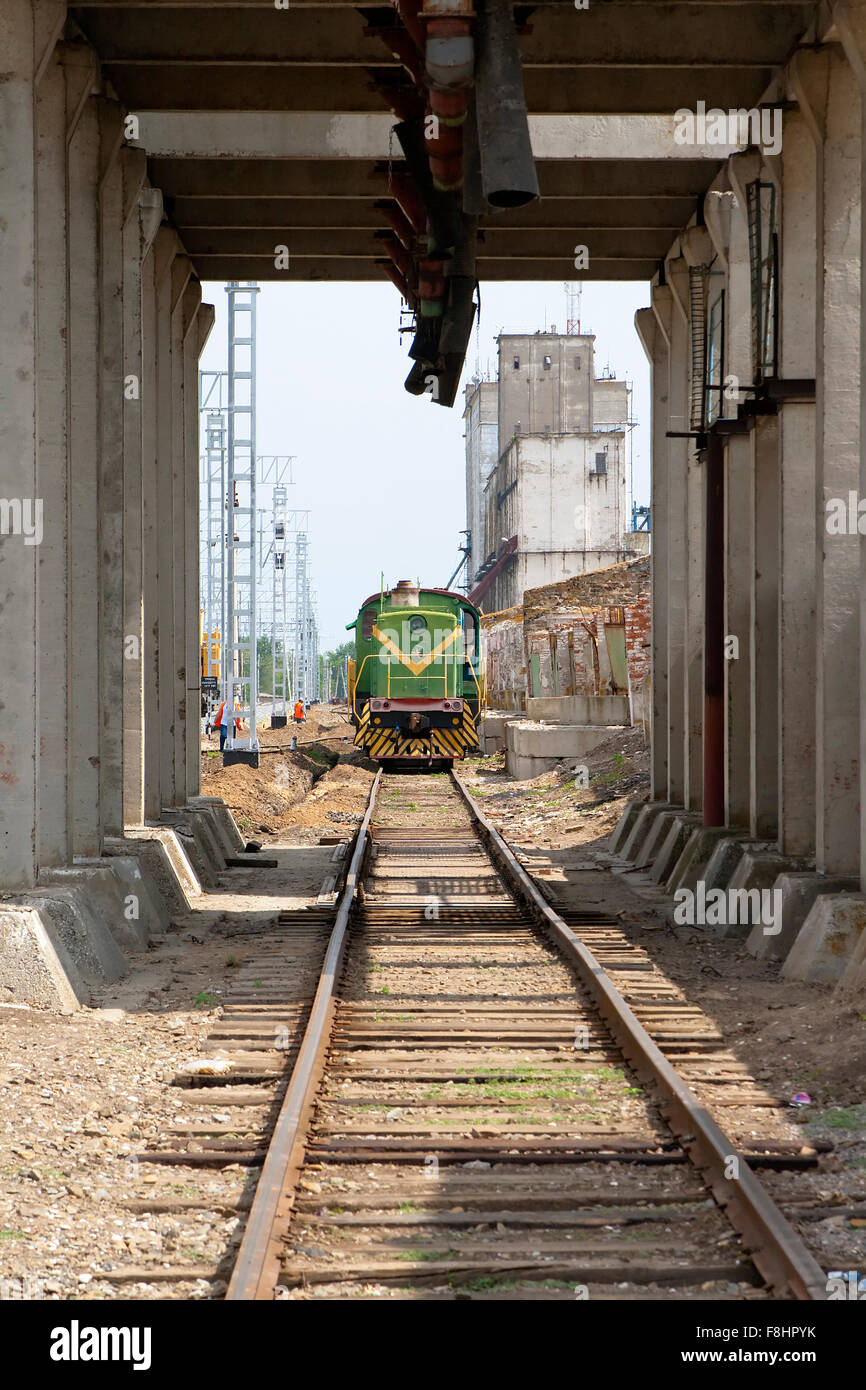 Die Lokomotive ist auf den Schienen nahe dem Bahnhof und der Laden-rack Stockfoto