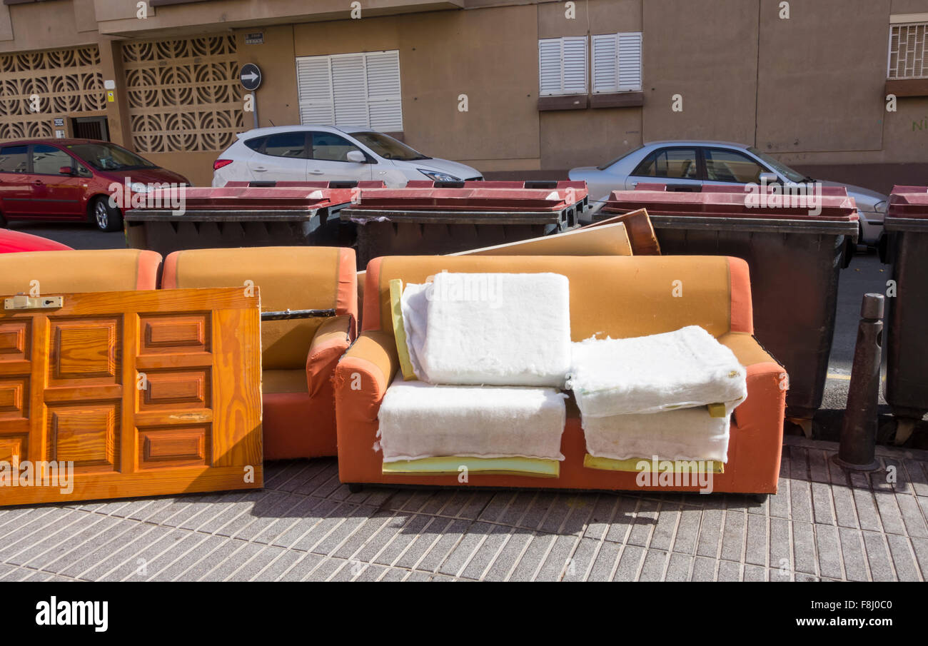 Sofa und Tür links in der Nähe communial Müllcontainer in der Straße in Spanien Stockfoto
