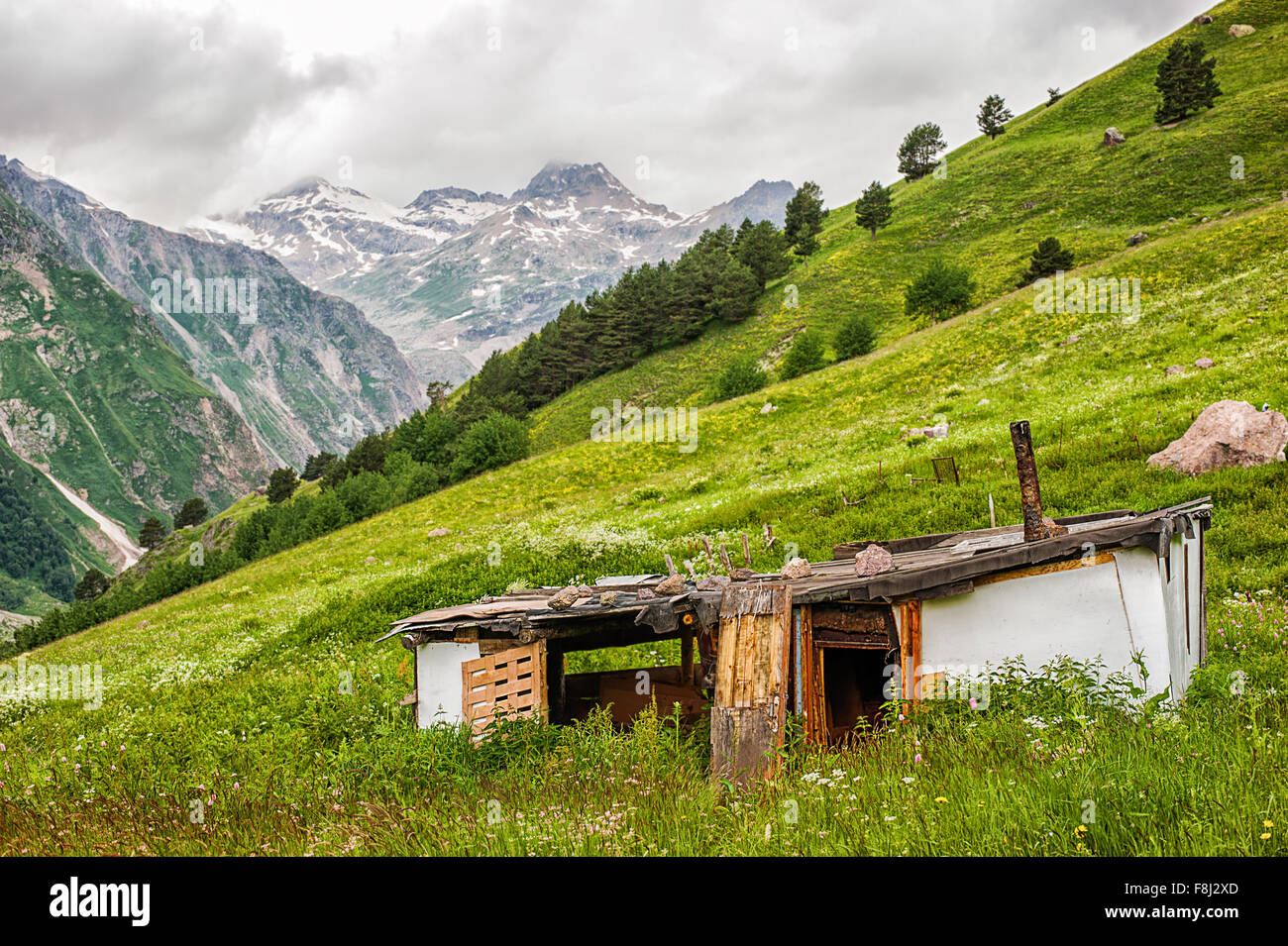 Armen alten baufälligen verlassenen Haus des Hirten auf der grünen Wiese im Tal der Berge, Elbrus-Region. Türen von h Stockfoto