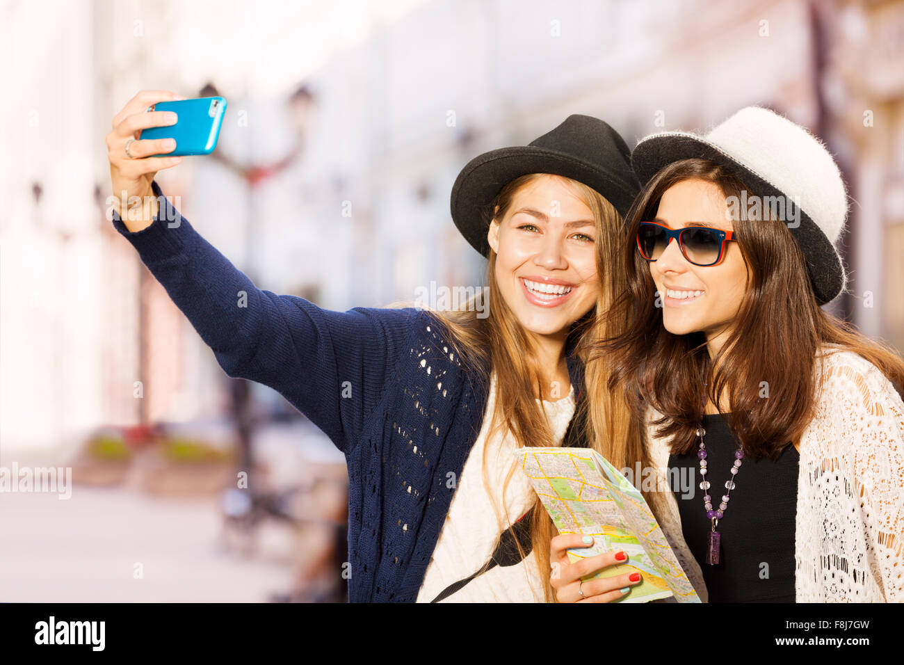 Zwei süße Mädchen, die die Selfies mit Handy Stockfoto