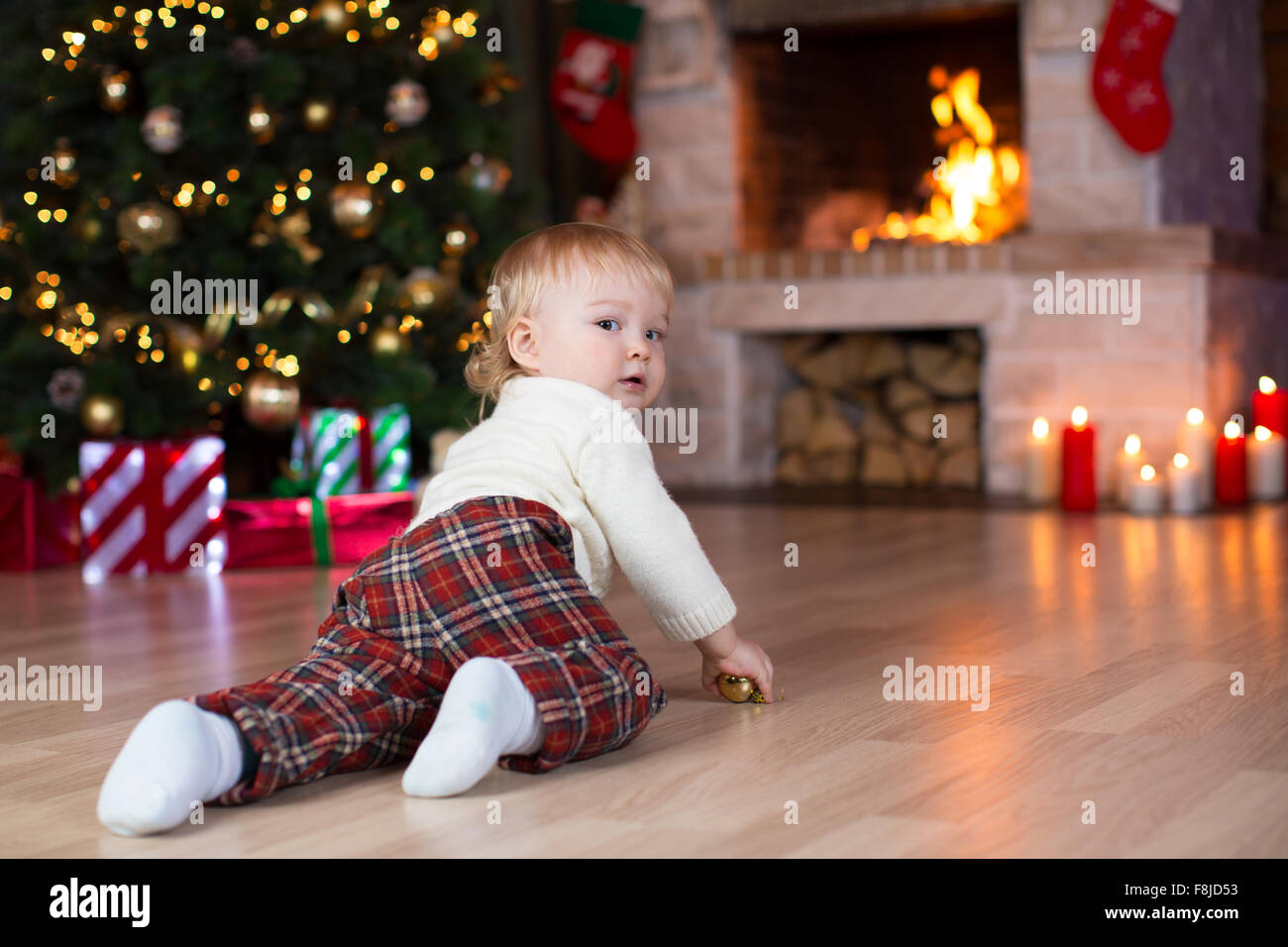 Kind krabbeln, Geschenke unter dem Weihnachtsbaum liegen Stockfoto