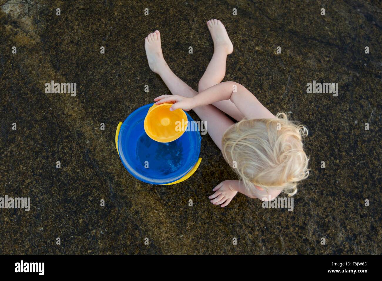 Draufsicht der weiblichen Kleinkind spielen im Sand mit Spielzeug Eimer Stockfoto