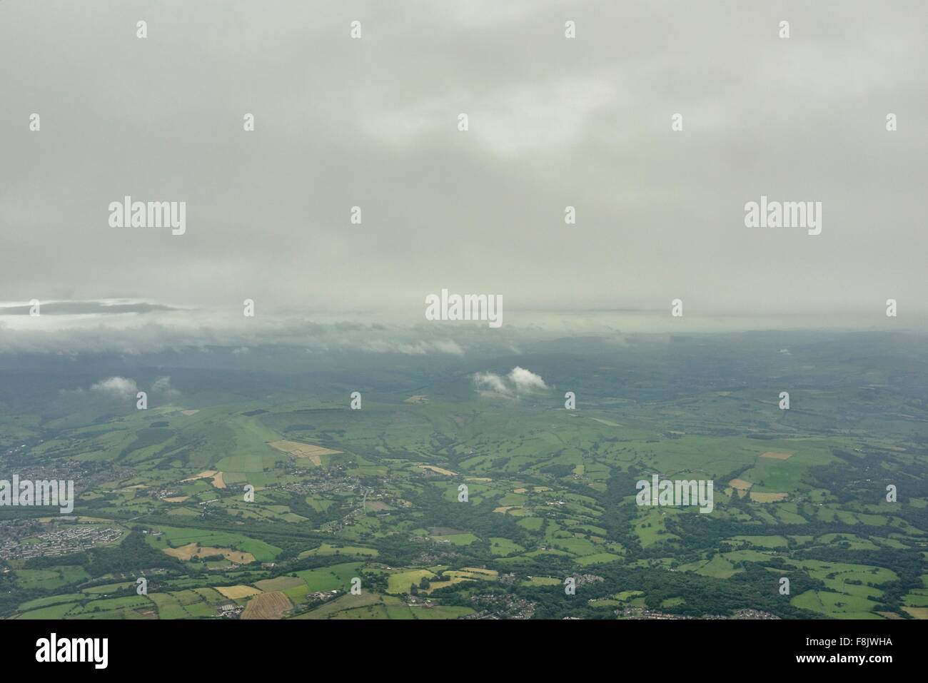 Luftbild von niedrigen Wolken und entfernten grünen Feldern, England. UK Stockfoto