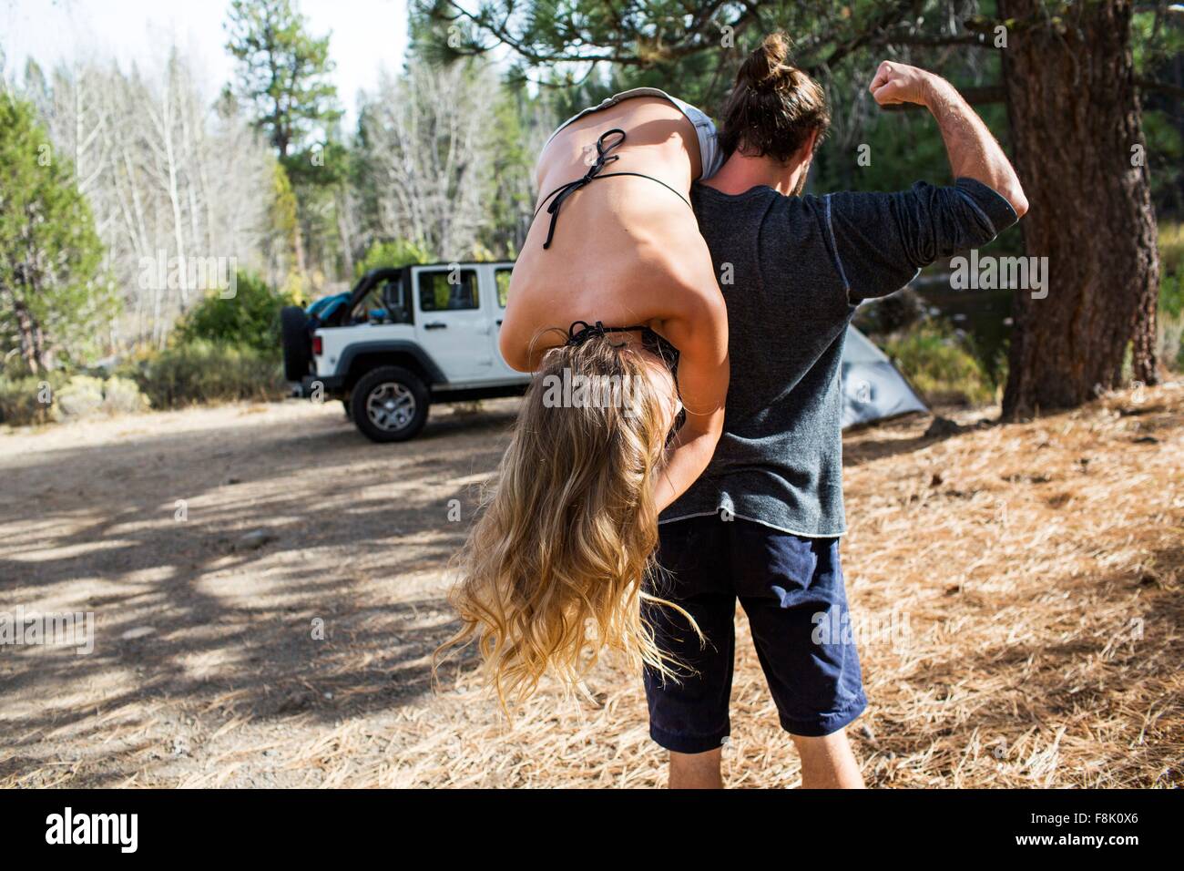 Rückansicht des jungen Mann mit Freundin über die Schulter auf Wald Campingplatz, Lake Tahoe, Nevada, USA Stockfoto