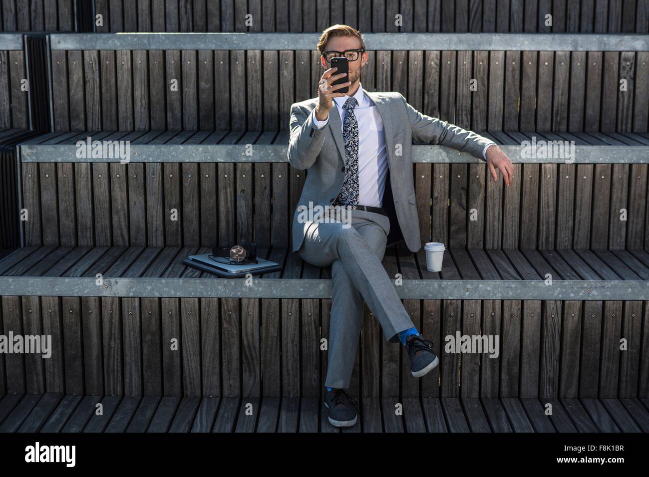 Coole junge Geschäftsmann lesen Smartphone auf Stadt-Treppe Stockfoto