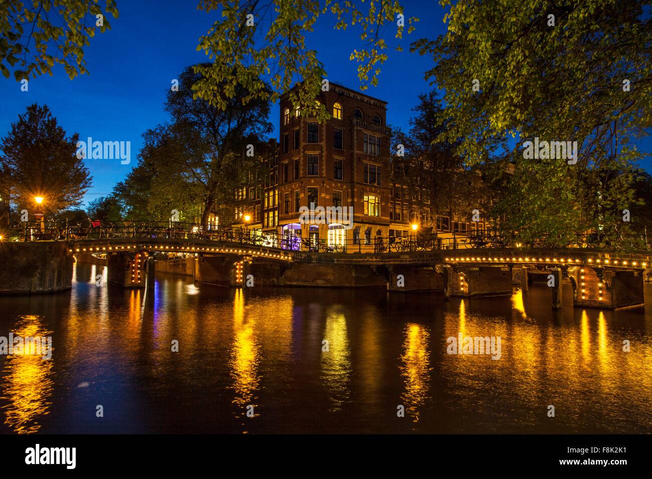 Kanal-Wasser und Brücke in der Nacht, Amsterdam, Niederlande Stockfoto