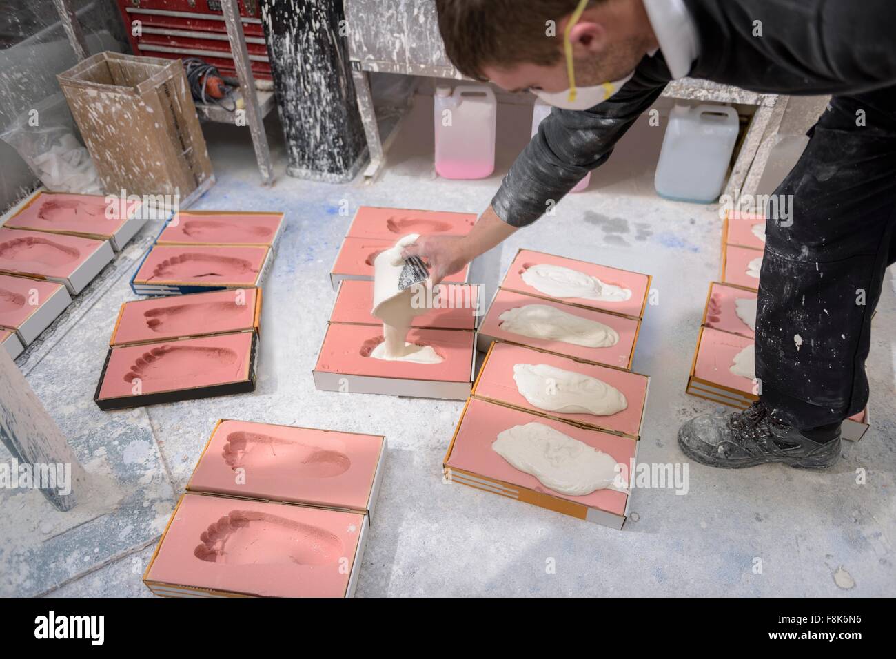 Arbeiter Casting Putz in Fuß Formen für orthopädische Unterstützung in Fabrik Stockfoto