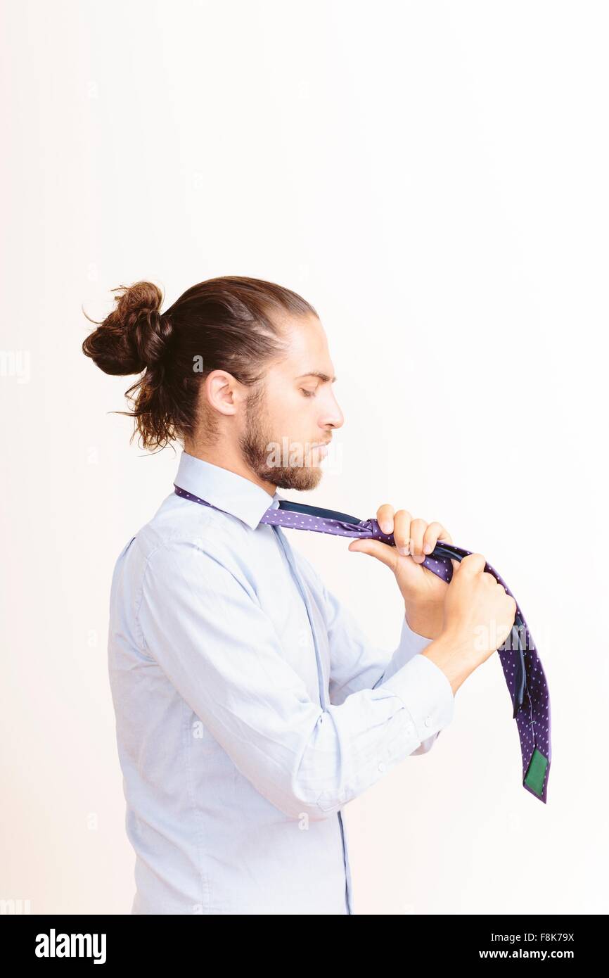 Junger Mann mit Haar in Knoten, ankleiden, Bindung Krawatte Stockfoto