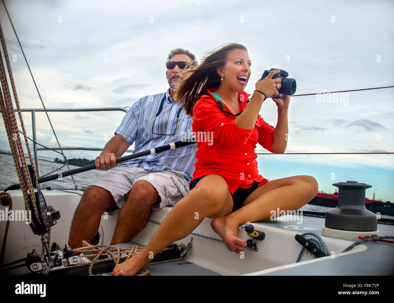 Junge Frau sitzt auf Segelboot dabei Foto lächelnd Stockfoto