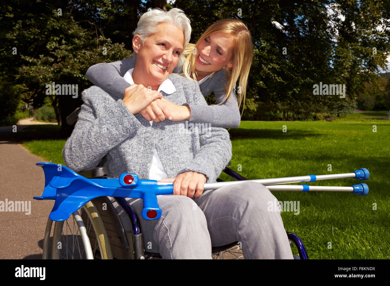 Glückliche Großmutter im Rollstuhl mit ihrem Enkelkind in einem park Stockfoto