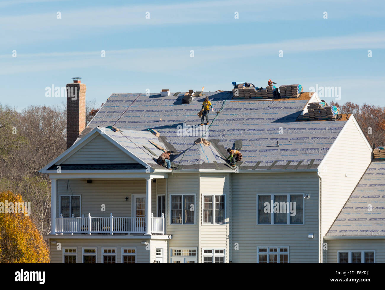 Arbeiter auf einer amerikanischen Hausdach Dach ersetzen fühlte mich bereit, Fliesen auf dem Dach, USA zu ersetzen Stockfoto