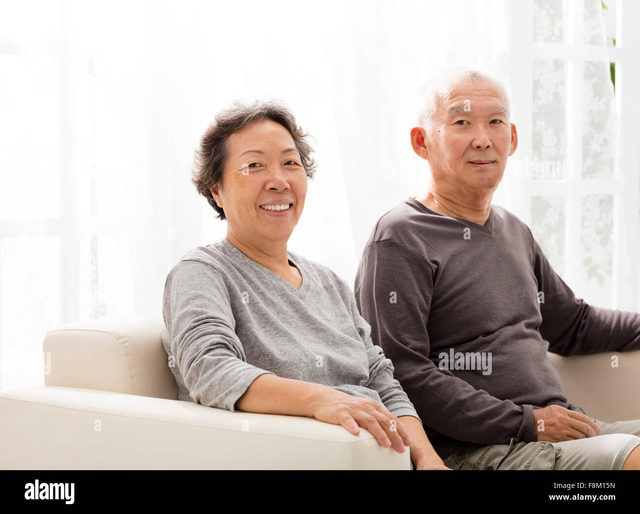 älteres paar sitzen nahe beieinander auf dem sofa Stockfoto
