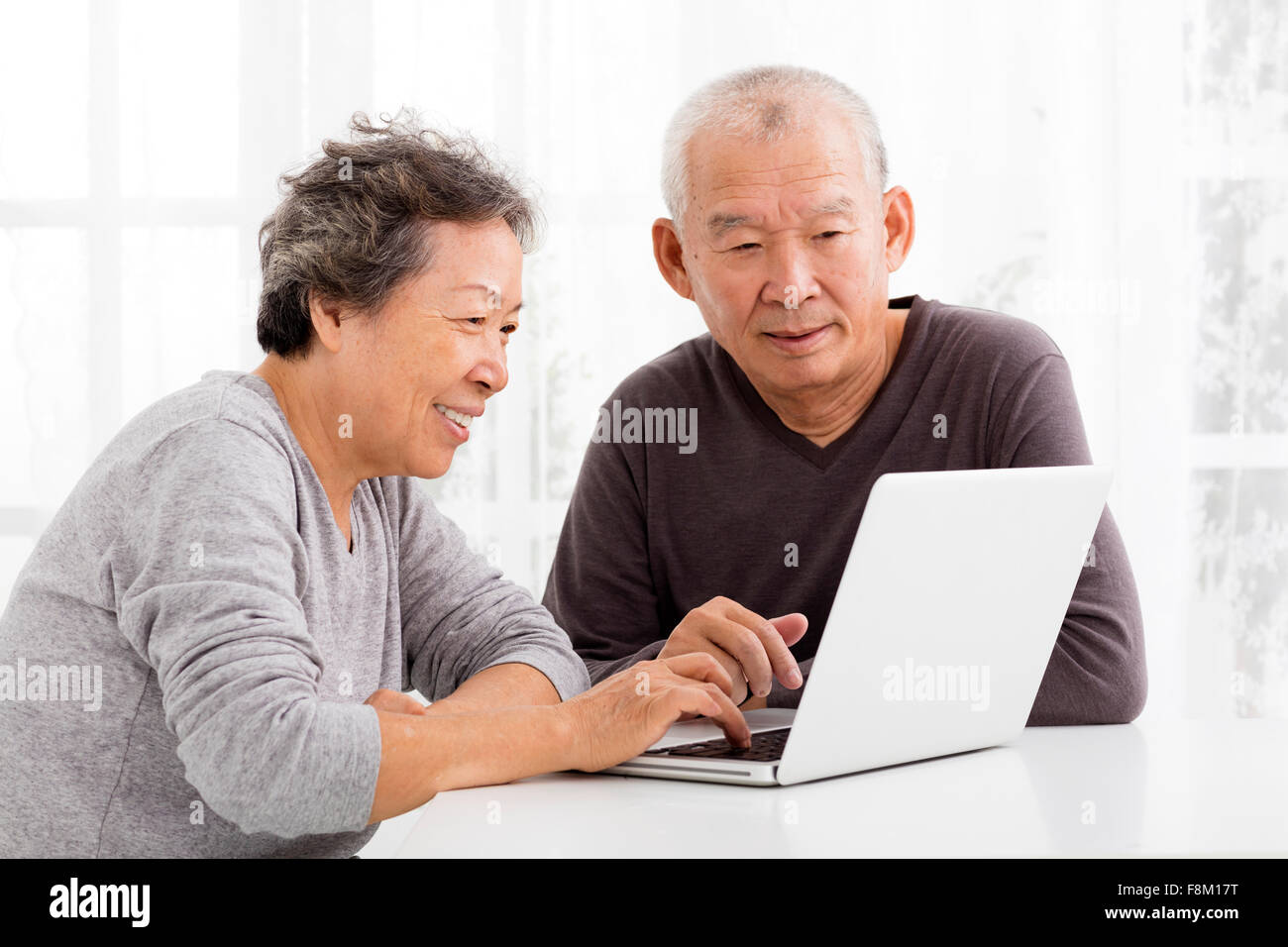 glücklich Senior paar mittels Laptop im Wohnzimmer Stockfoto