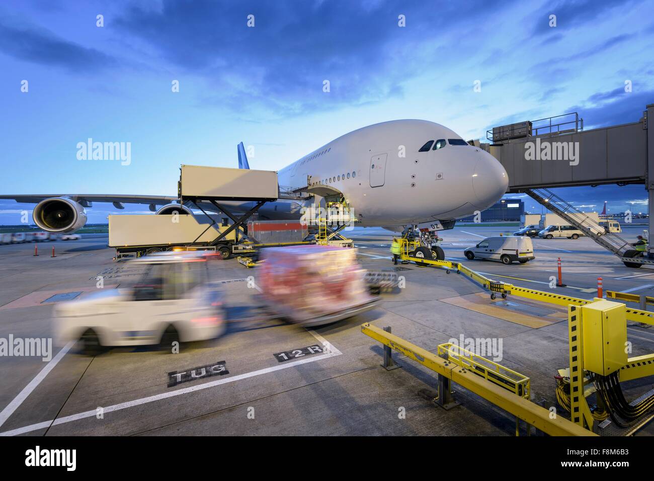 Dämmerung über A380-Flugzeuge auf Stand am Flughafen mit Bodenfahrzeugen in Bewegung Stockfoto