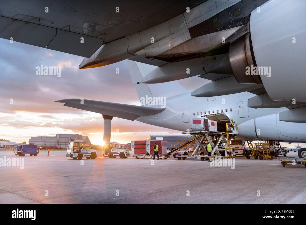 Bodenpersonal laden A380-Flugzeuge bei Sonnenuntergang Stockfoto