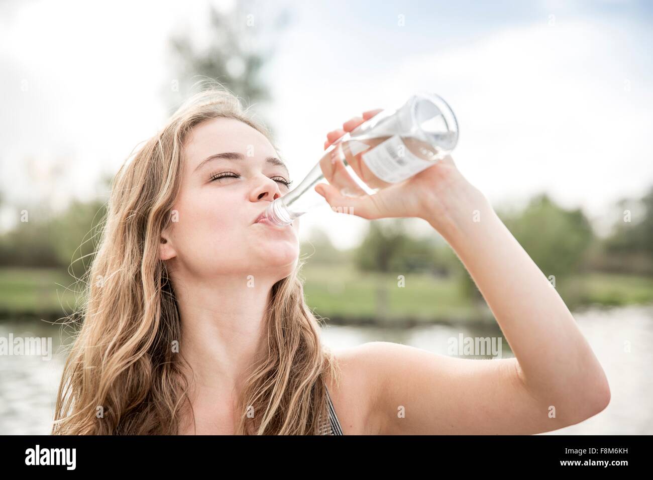 Junge Frau Trinkwasser aus der Flasche, im freien Stockfoto