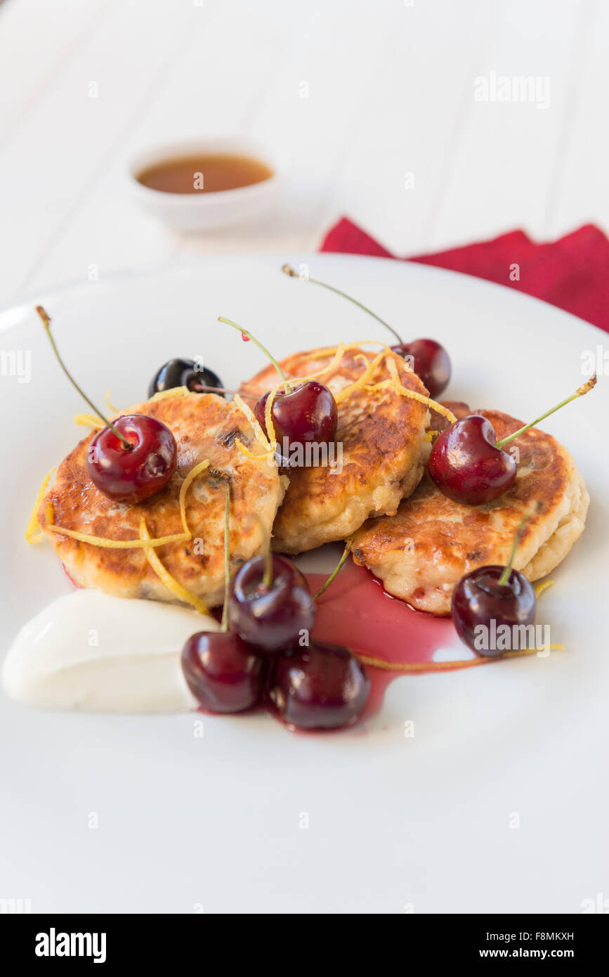 Frischkäse und Quark Krapfen, englische Sommer Kirschen und Crème frisch. Stockfoto