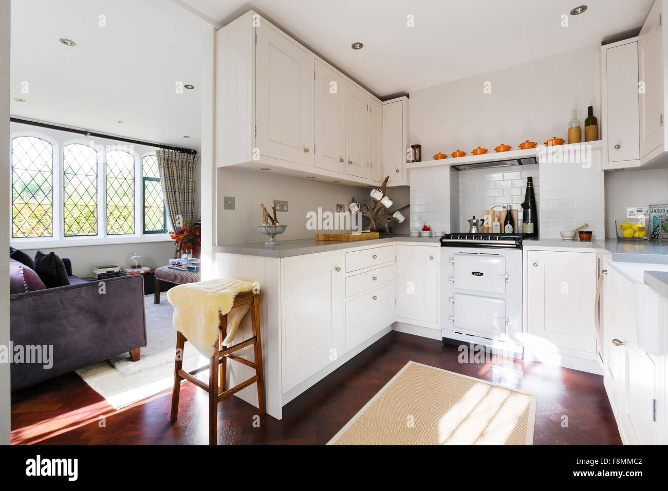 Grad II aufgeführten Country Lodge in Weybridge. Der Küchenbereich mit weiß gestrichenen Einheiten und traditionellen Aga-Style-Ofen-Sortiment Stockfoto