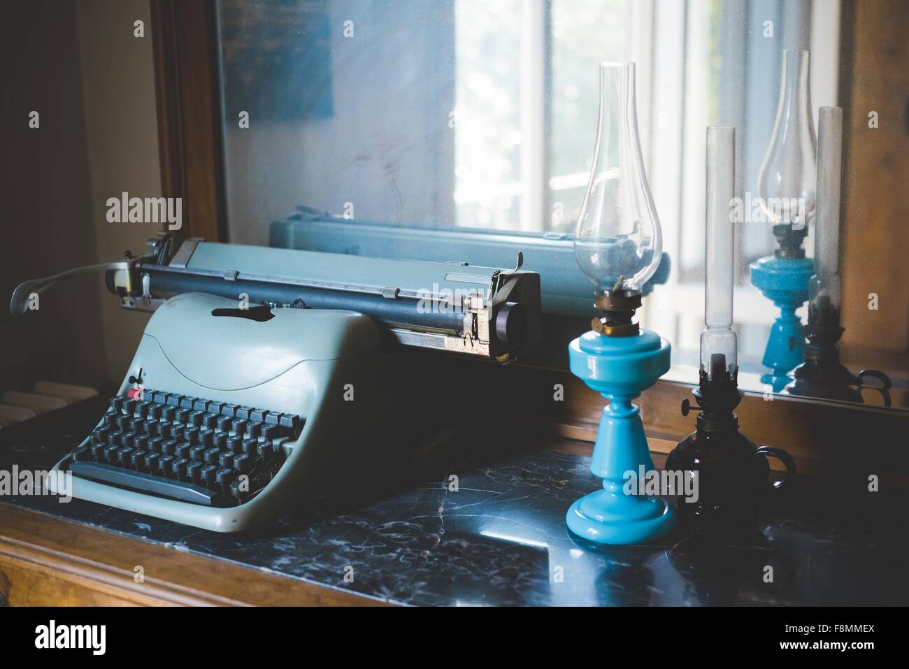 Vintage Schreibmaschine und Öl-Lampen auf Tisch Stockfoto