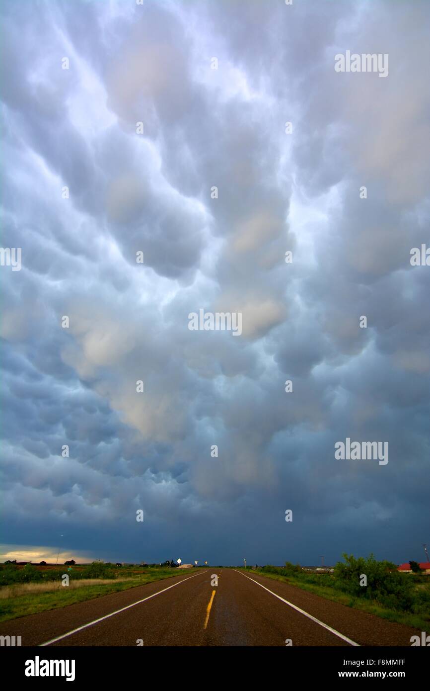 Abnehmende Perspektive der offenen Straße und Mammatus Wolken nach Stürmen, in der Nähe von Tucumcari, New Mexico, USA Stockfoto