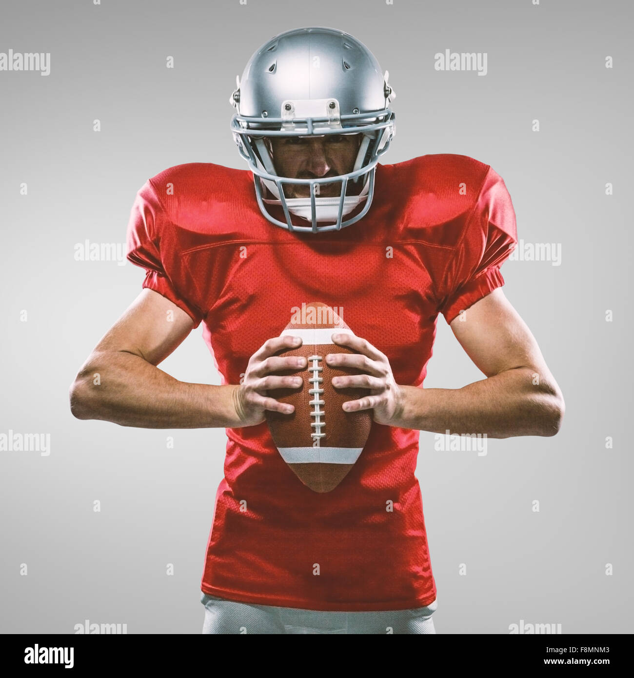 Zusammengesetztes Bild von wütenden american Footballspieler in roten Trikots und Helm mit ball Stockfoto
