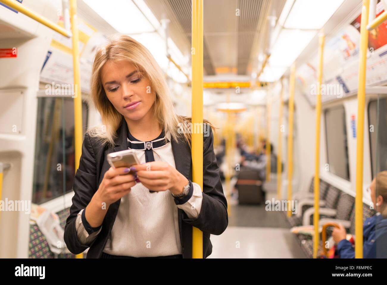 Geschäftsfrau SMS auf Rohr, London Underground, UK Stockfoto