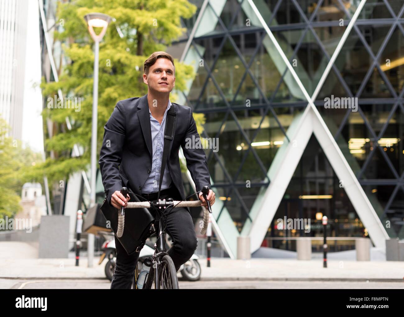 Geschäftsmann am Fahrrad, 30 St Mary Axe im Hintergrund, London, UK Stockfoto