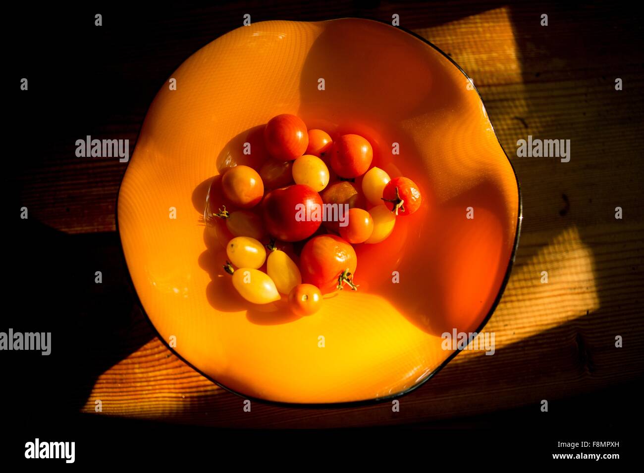 Draufsicht der Tomaten in orange Schüssel auf Holztisch Stockfoto