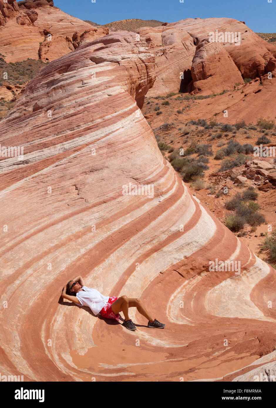 Mädchen, liegend in der Wüste Welle des Valley of Fire, Nevada Stockfoto