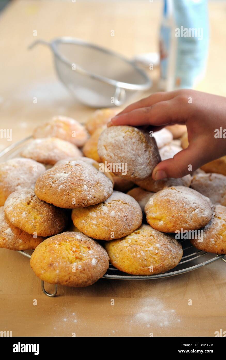 Ein wenig Boyâ€™ s Hand unter einer italienischen Kürbis Keks Stockfoto