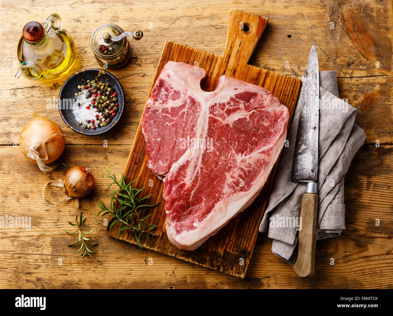 Rohes Frischfleisch t-Bonesteak und Gewürze auf hölzernen Hintergrund Stockfoto
