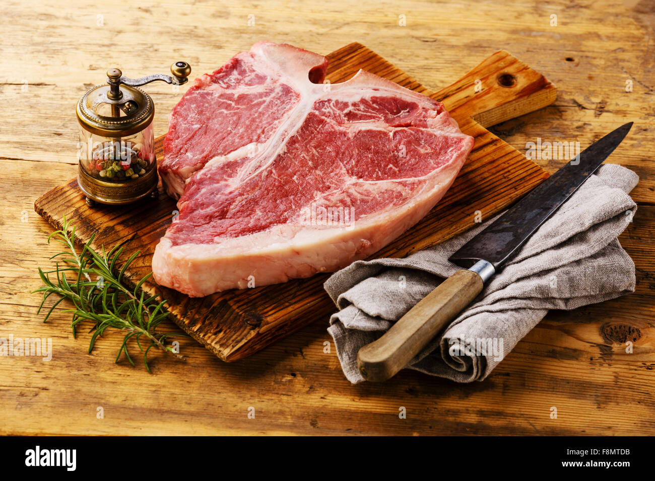 Rohes Frischfleisch t-Bonesteak und Gewürze auf hölzernen Hintergrund Stockfoto