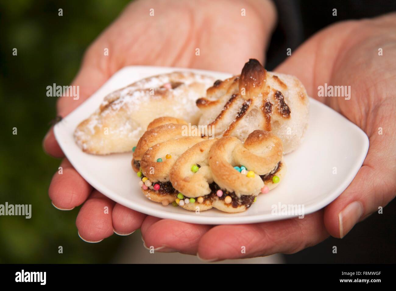 Eine Frau hält eine kleine Schüssel mit sizilianischen Mandel Gebäck Stockfoto