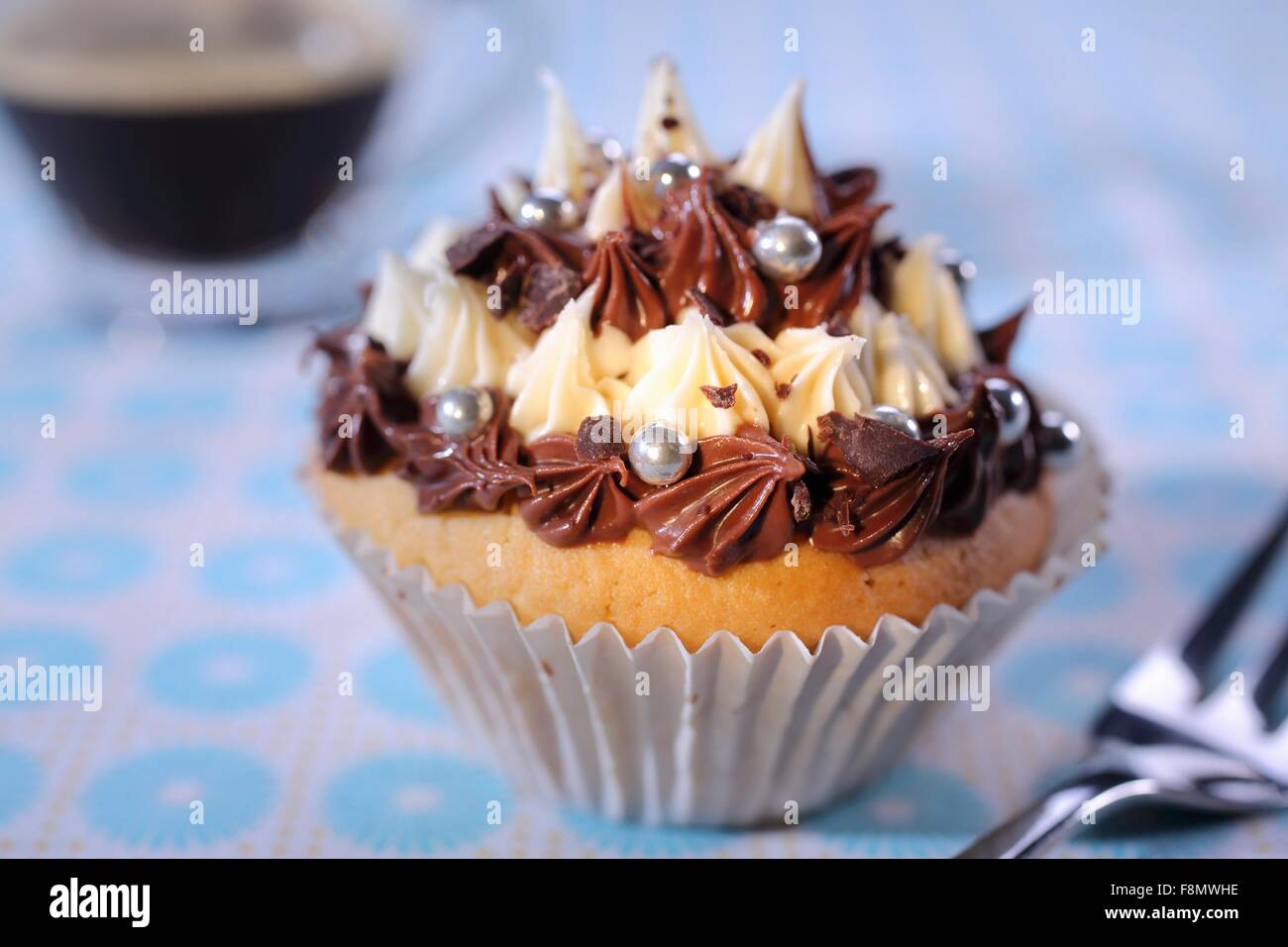 Ein Cupcake mit Pipe Creme Sahnehäubchen und silbernen Kugeln Stockfoto