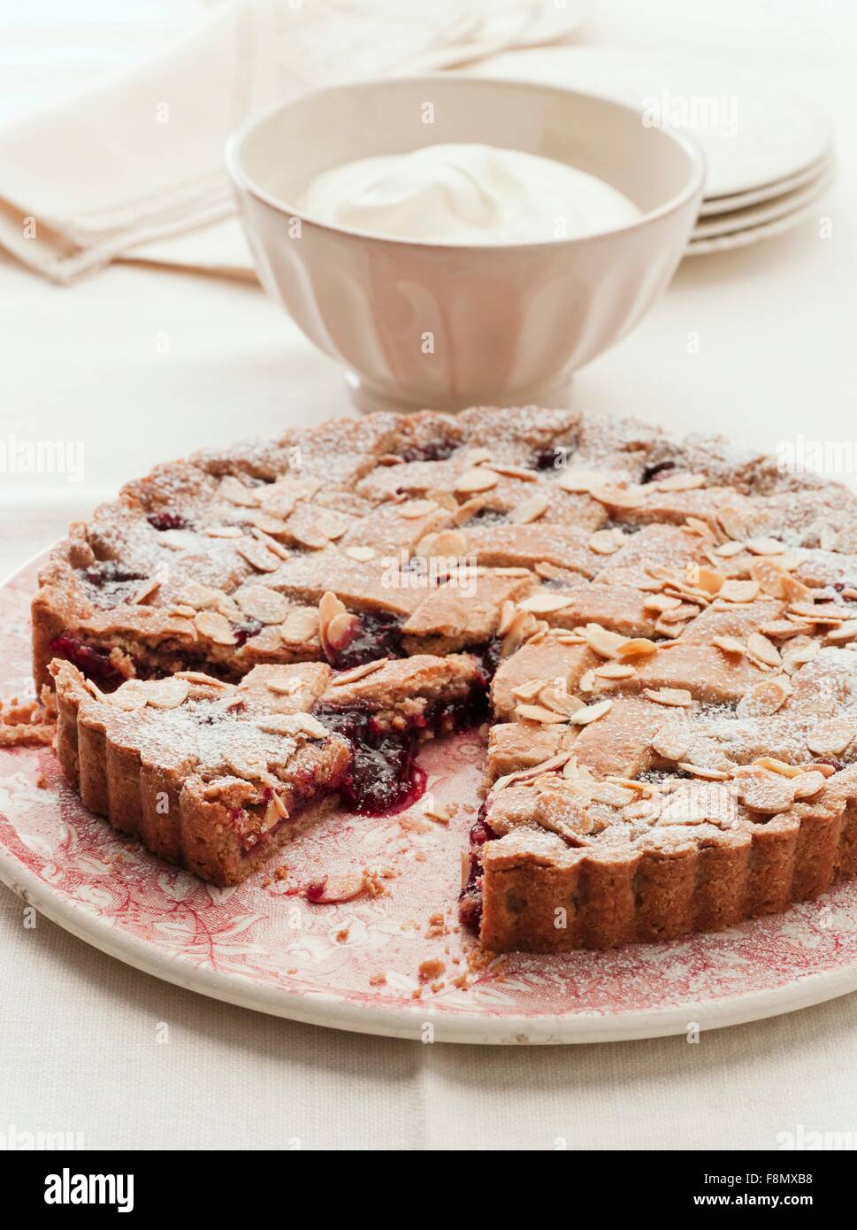 Linzer Torte (Mutter und Konfitüre Torte) mit Mandelsplitter, teilweise in Scheiben geschnitten Stockfoto