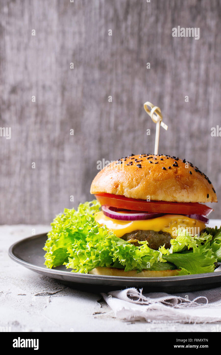 Frische hausgemachte Hamburger mit schwarzem Sesam in Vintage Metallplatte, diente über weiß verputzten Tabelle und weißem Textil Witz Stockfoto