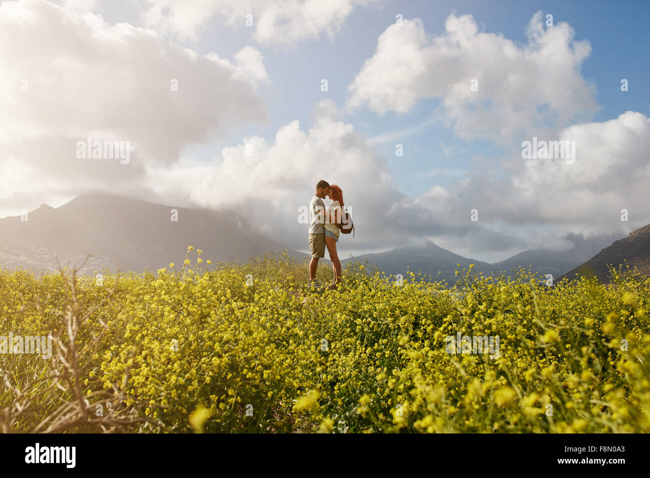 Romantische junges Paar umarmt und sahen einander, stehend auf einem Hügel im Freien an einem Sommertag. Junger Mann und Stockfoto