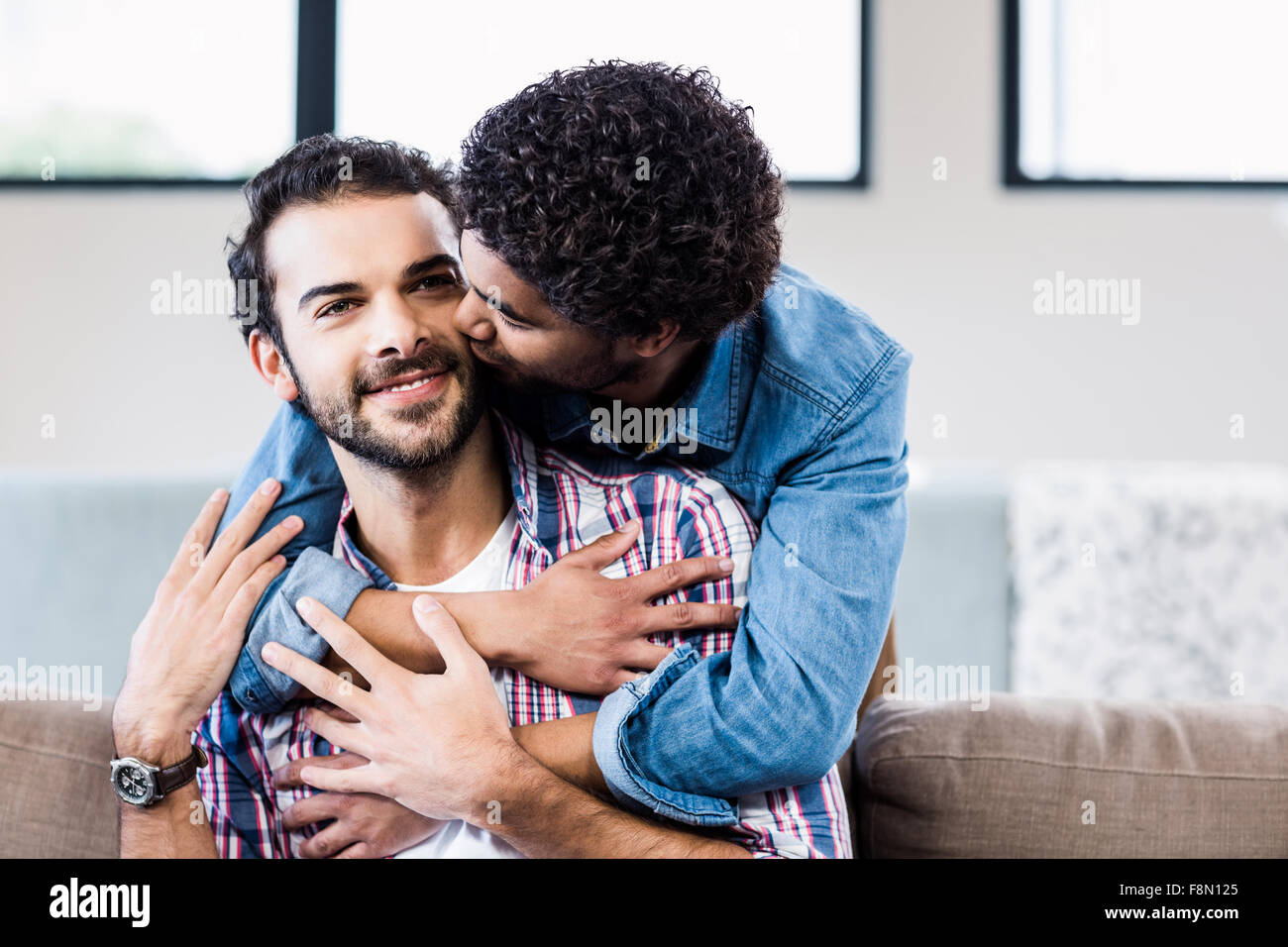 Gut aussehender Mann seinen Partnern Wange küssen Stockfoto