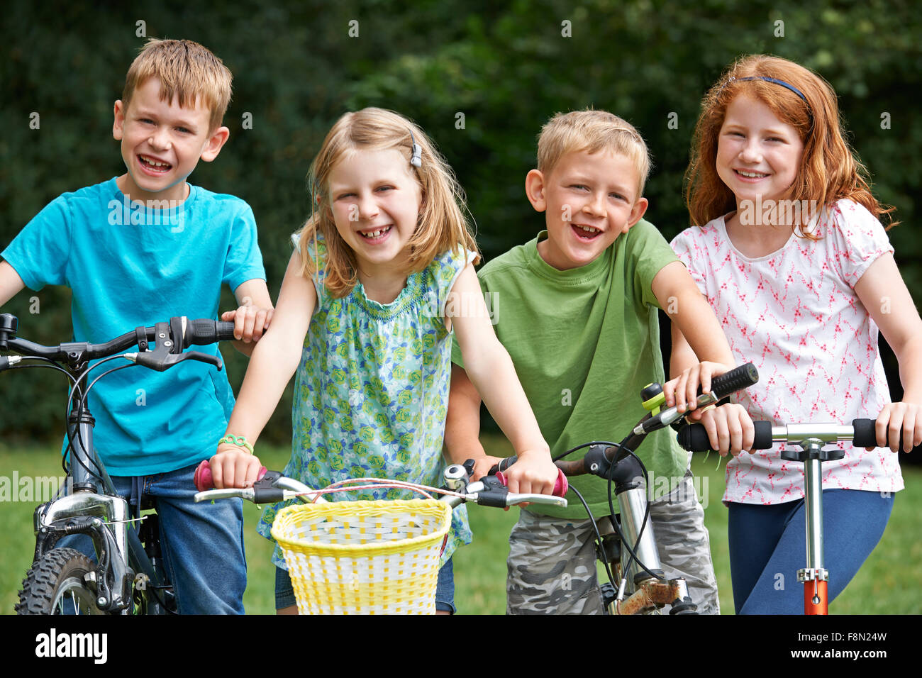 Gruppe von Kindern spielen auf Bikes und Scooter Stockfoto