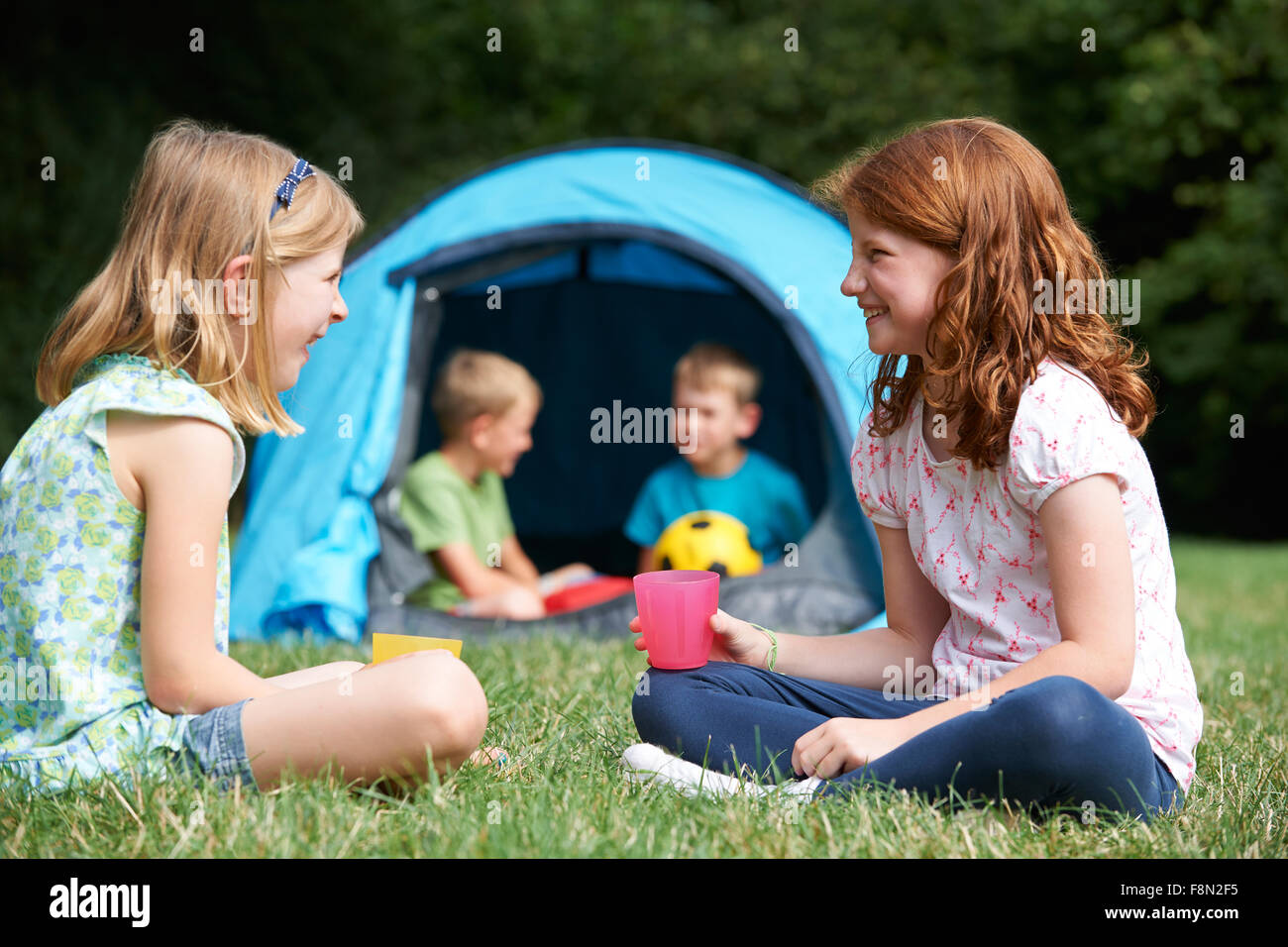 Zwei Mädchen im Chat zusammen auf Camping-Ausflug Stockfoto
