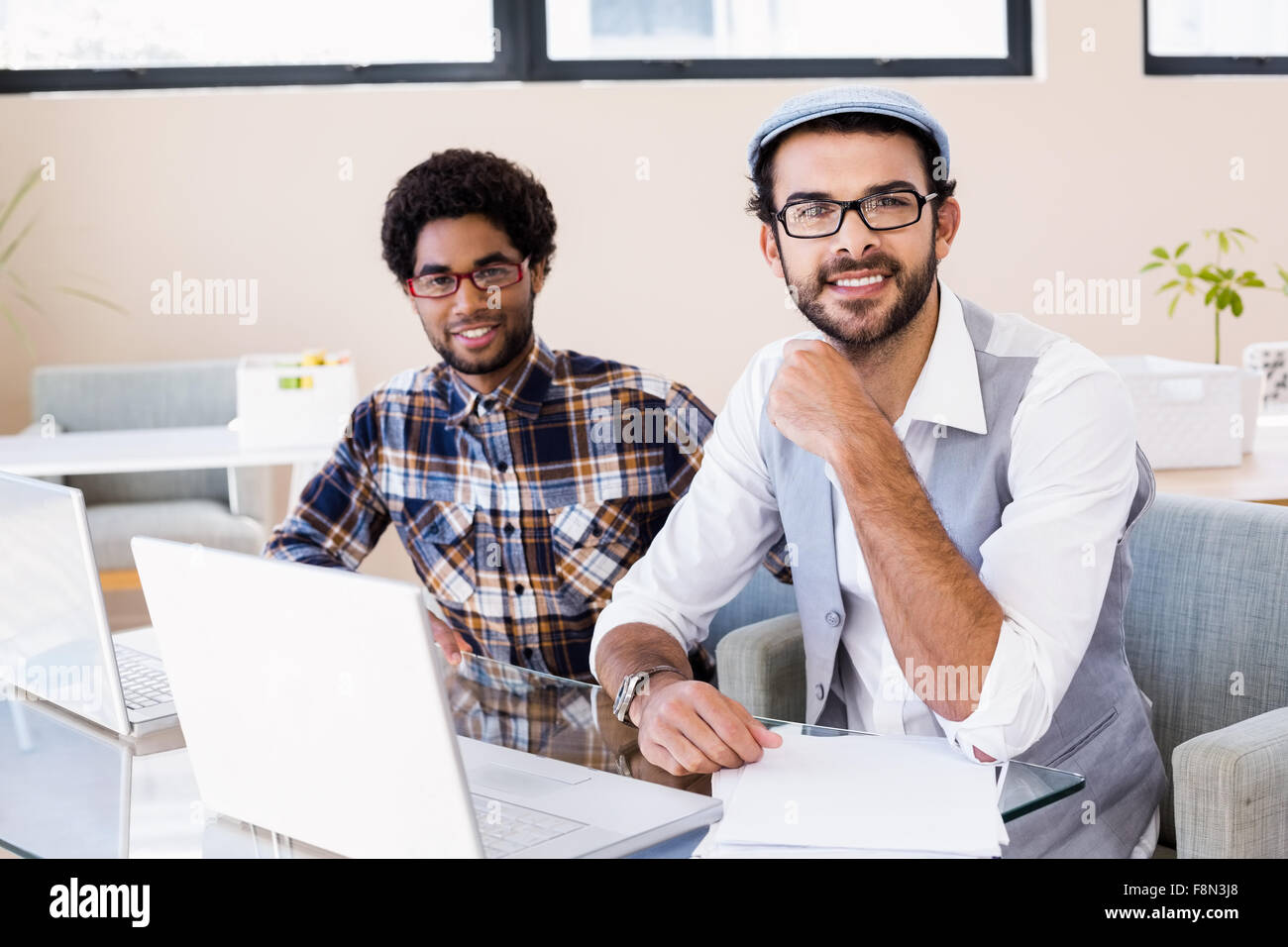 Lächelnde schwules Paar mit Notebooks Stockfoto