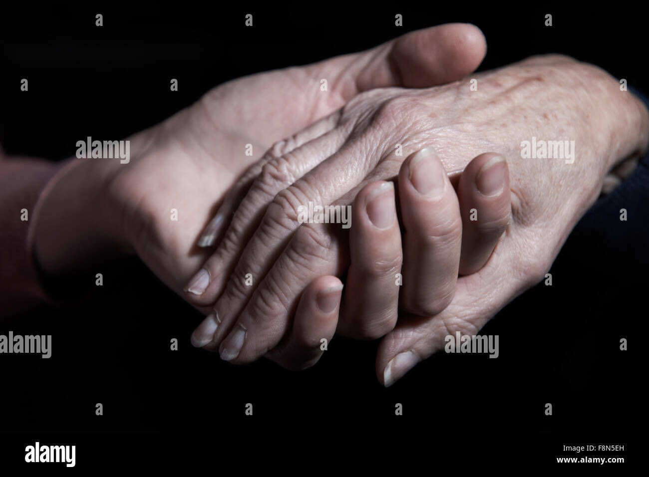 Junge Frau, die ältere Frau Hand hält Stockfoto