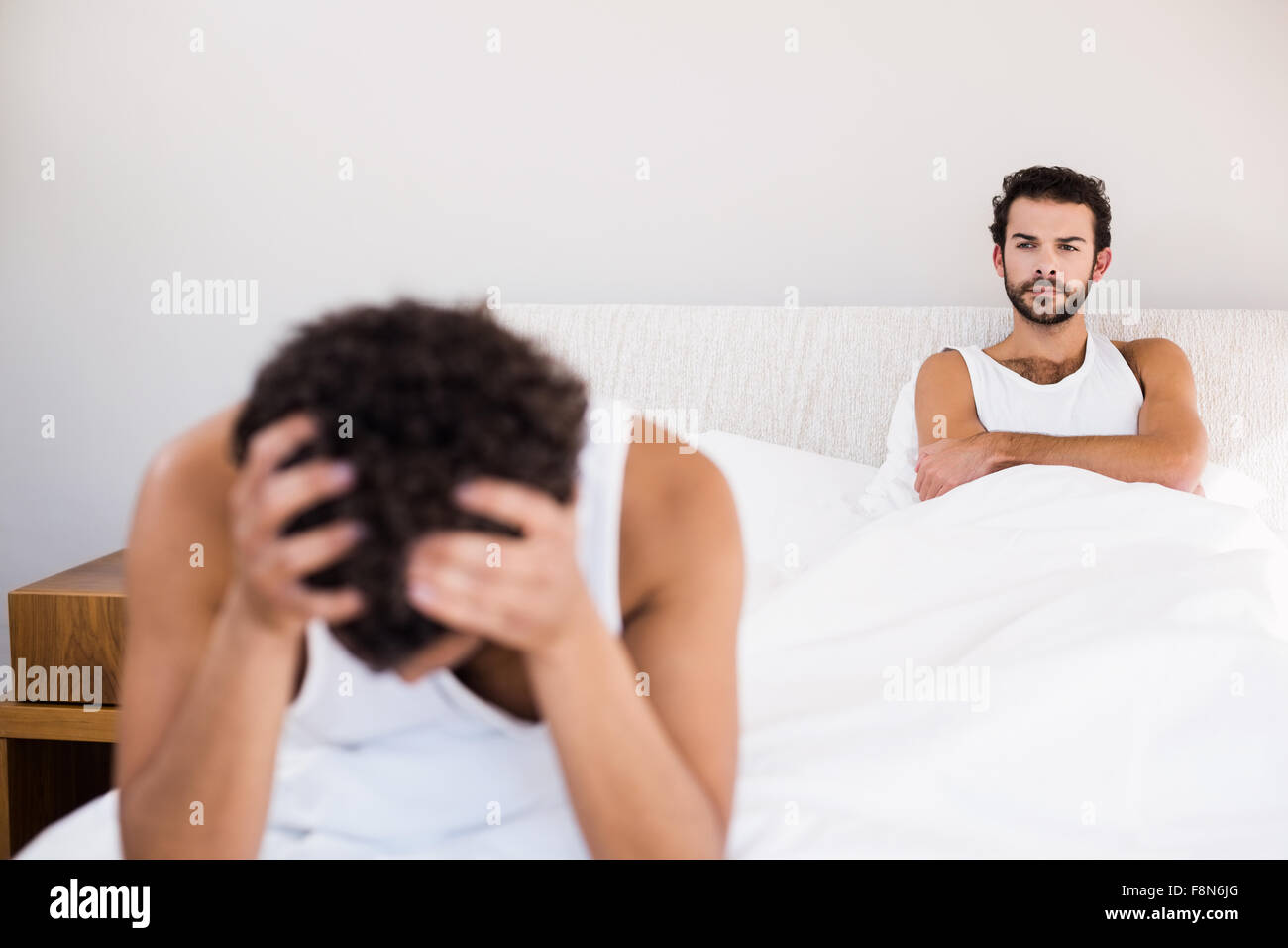 Stirnrunzelnd Mann mit verschränkten Armen sah seine Partnerin nach dem argument Stockfoto