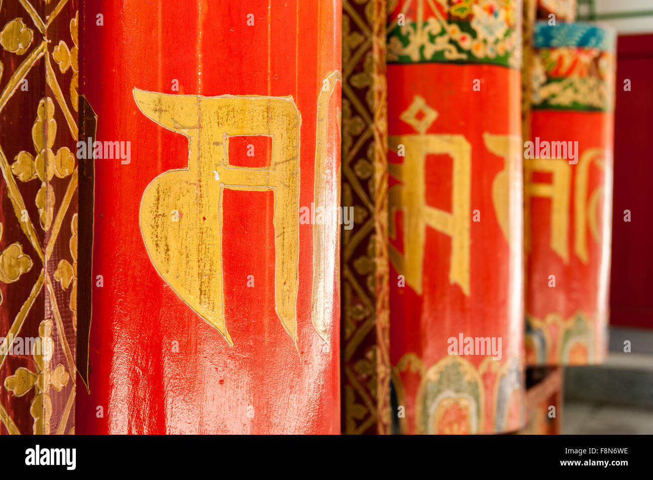 Asiatische rote Gebetsmühlen mit dem traditionellen schreiben in gold Stockfoto